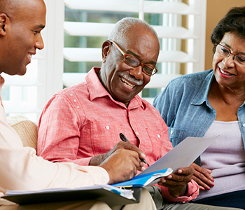 Financial Advisor Talking To Senior Couple At Home